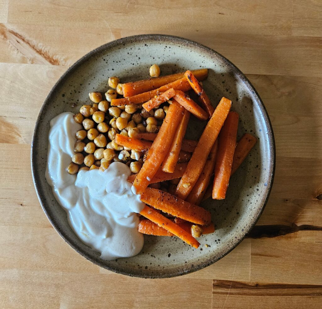Assiette de carottes et pois chiches rôtis avec une sauce yaourt