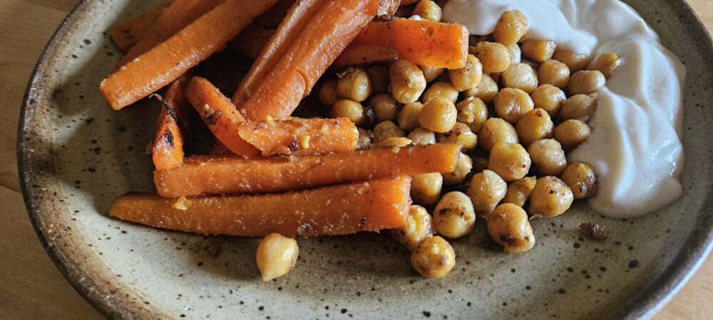 Assiette de carottes et pois chiches rôtis avec une sauce yaourt
