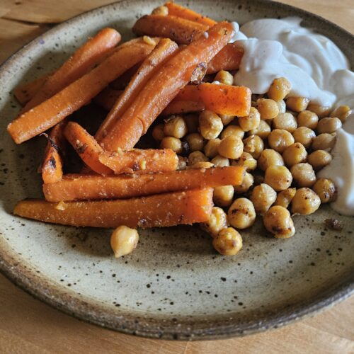 Assiette de carottes et pois chiches rôtis avec une sauce yaourt