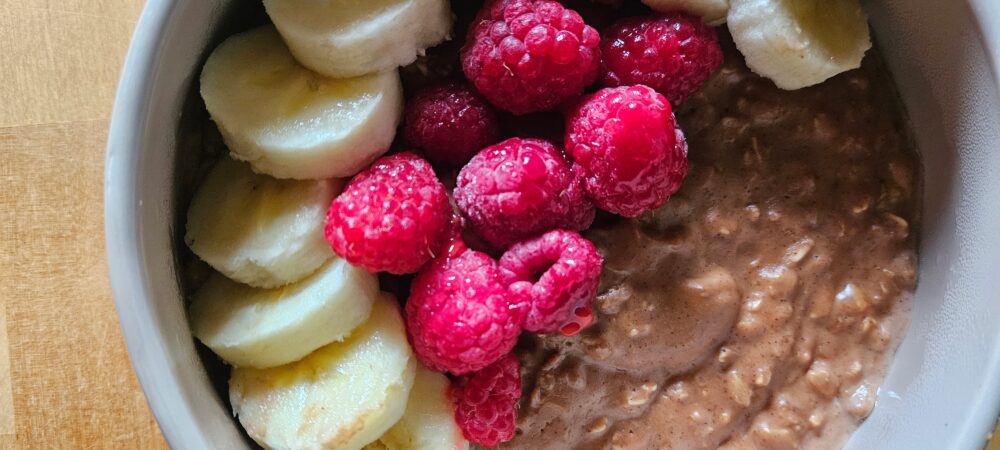 Bol de porridge chocolat noisette, bananes et framboises