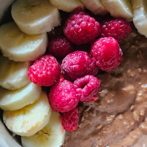 Bol de porridge chocolat noisette, bananes et framboises