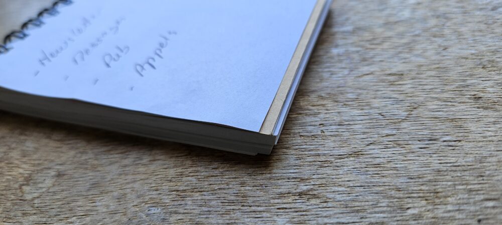 Petit carnet de notes posé sur une table en bois