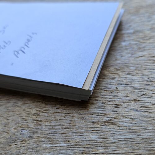 Petit carnet de notes posé sur une table en bois