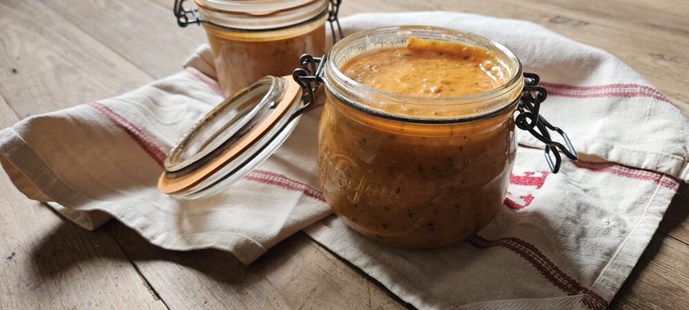Deux bocaux de sauce tomate posés sur un torchon de cuisine.