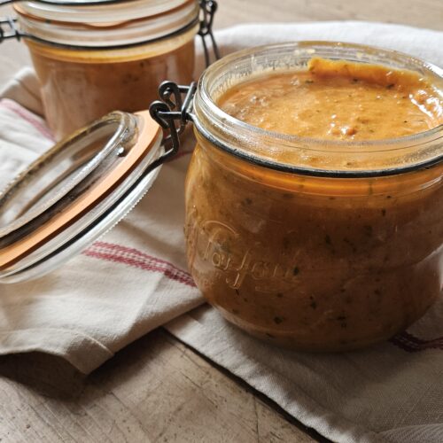 Deux bocaux de sauce tomate posés sur un torchon de cuisine.